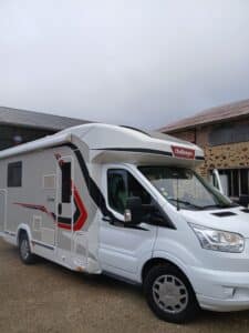 Camping-car blanc Challenger garé devant bâtiment
