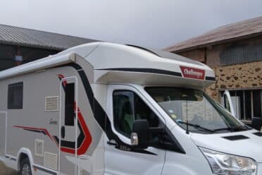 Camping-car blanc Challenger garé devant bâtiment