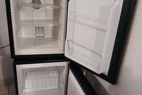 Mini-frigo aperti e vuoti su pavimenti piastrellati