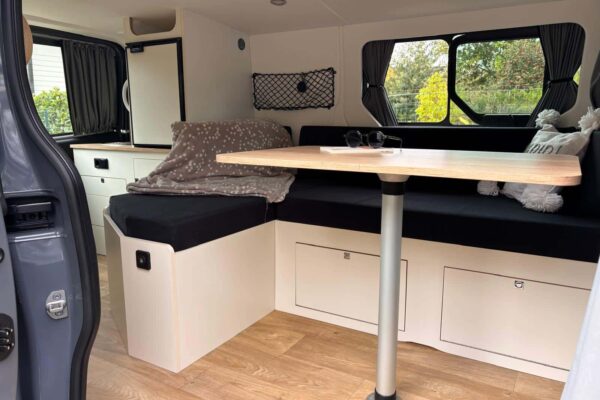 Intérieur moderne de van aménagé avec kitchenette et lit