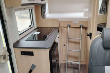 Moderne Inneneinrichtung von Wohnmobil mit Küche und Bett