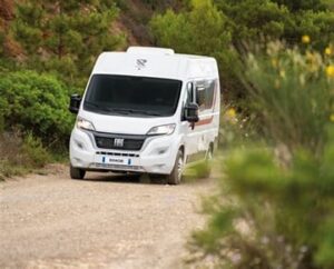 Camping-car Fiat roulant sur un chemin de campagne