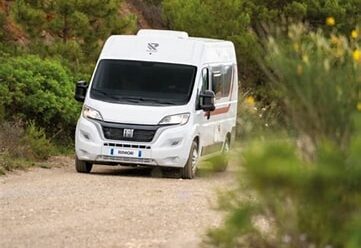 Camping-car Fiat roulant sur un chemin de campagne