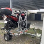 Moto rouge sur remorque métallique
