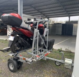 Moto rouge sur remorque métallique