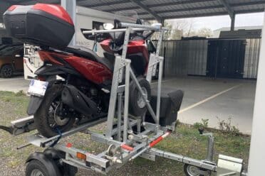 Moto rouge sur remorque métallique