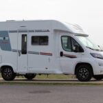 Camping-car blanc garé près de la côte