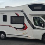 Camping-car moderne blanc garé en extérieur