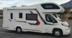 Camping-car moderne blanc garé en extérieur