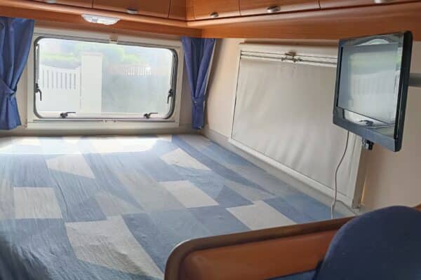 Heller Innenraum eines Wohnwagens mit Fenstern und Vorhängen