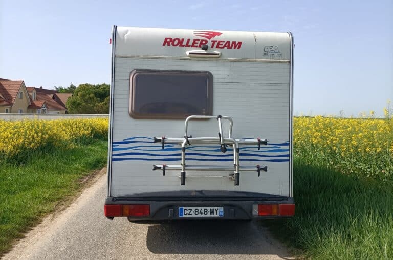Camping-car stationné près d'un champ de fleurs jaunes