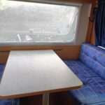 Intérieur cosy de caravane avec table et banquettes