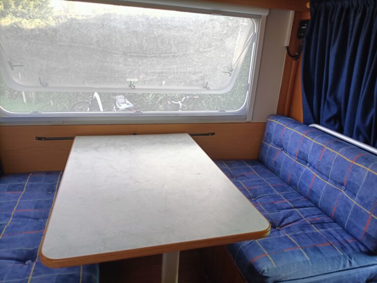 Intérieur cosy de caravane avec table et banquettes