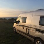 Camping-car en bord de mer au coucher du soleil