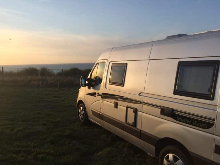 Camping-car en bord de mer au coucher du soleil