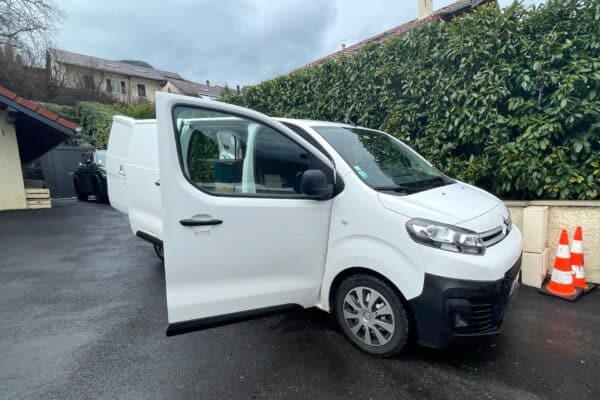 Fourgon blanc stationné, porte avant ouverte