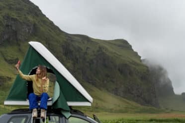 Femme prenant un selfie en montagne depuis un toit de voiture