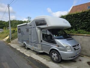 Camping-car gris stationné près d'une route