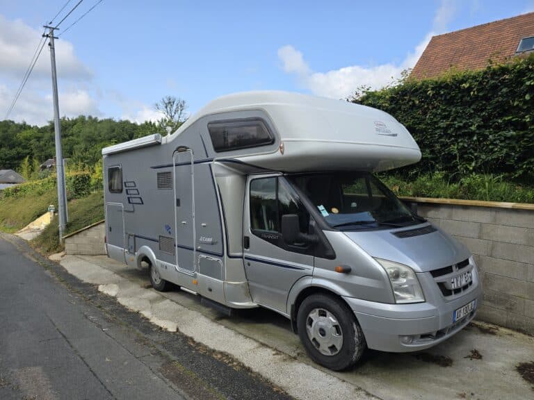 Camping-car gris stationné près d'une route