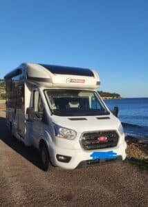 Camping-car blanc stationné près de la mer