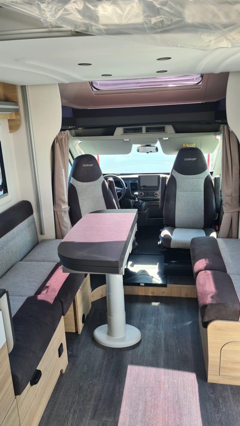 Intérieur d'un camping-car moderne avec sièges et table.