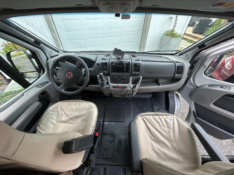 Intérieur de voiture avec volant et sièges avant.