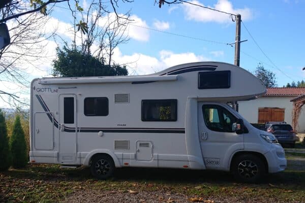 Camping-car blanc stationné sous le ciel bleu