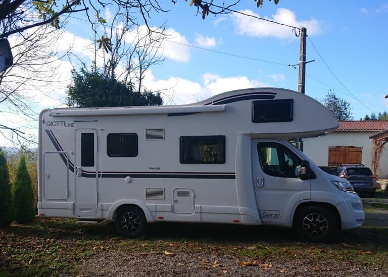 Camping-car blanc stationné sous le ciel bleu