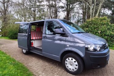 Van gris avec aménagement camping intérieur.