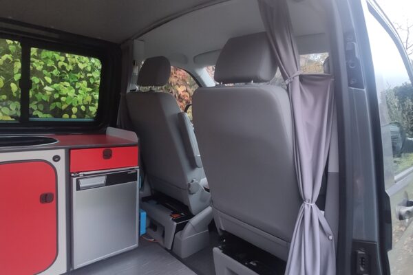 Inneneinrichtung von Campervan mit Küche und Sitzgelegenheiten.