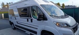 Camping-car blanc garé sur une allée pavée.