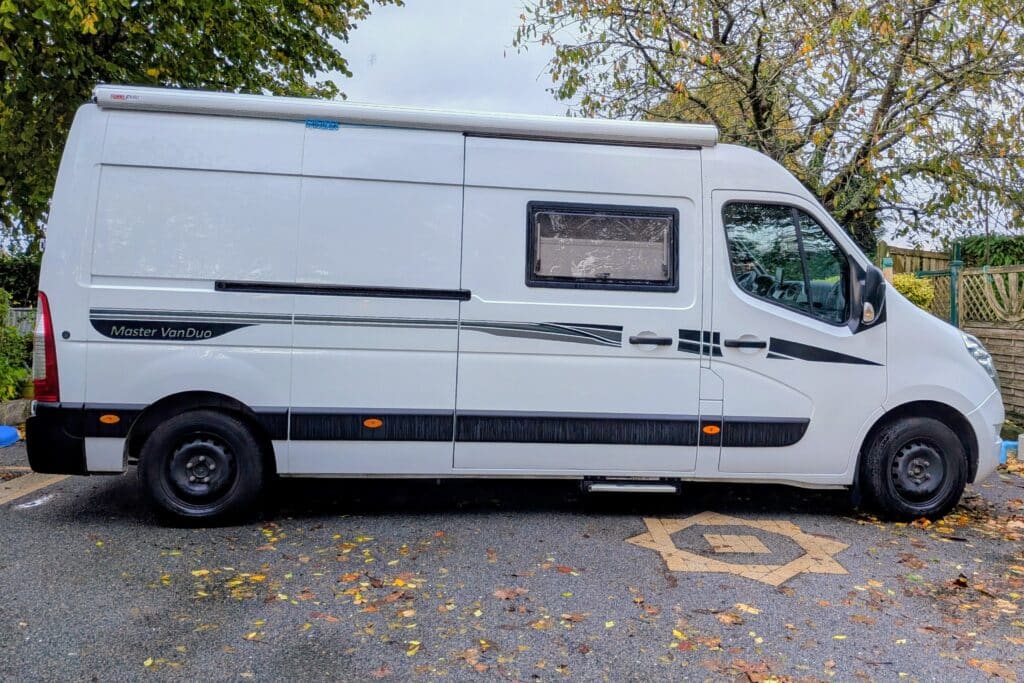 Camping-car blanc garé sur la route