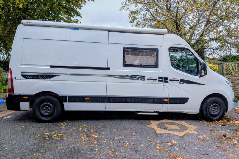 Camping-car blanc garé sur la route