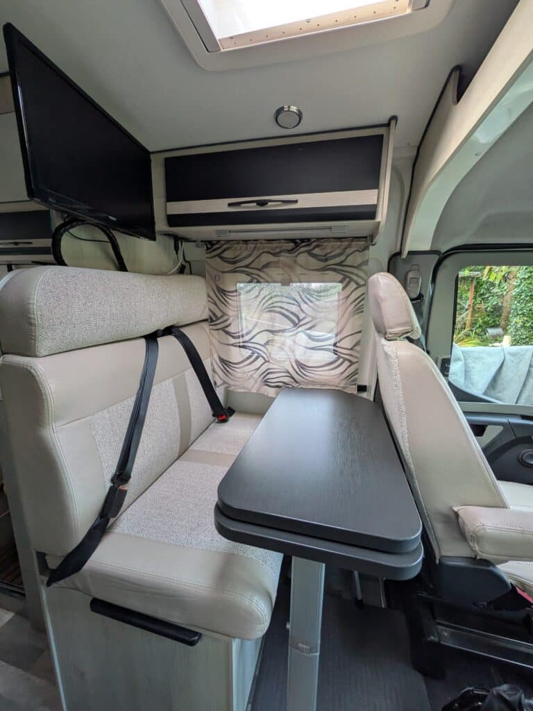 Intérieur d'un camping-car moderne avec table et sièges.