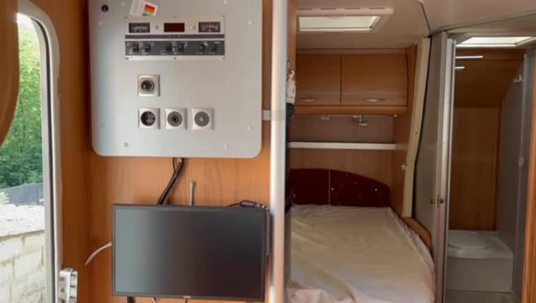 Intérieur d'un camping-car avec lit et salle de bain.