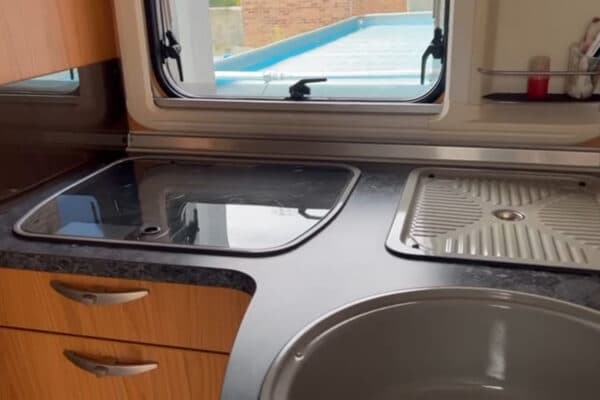 Cuisine compacte avec évier et plaque de cuisson.