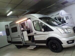 Camping-car moderne en exposition intérieure.