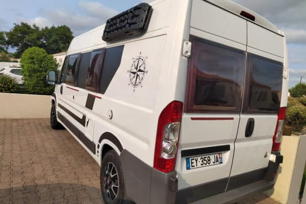 Weißer Wohnmobil parkt auf gepflasterter Auffahrt.