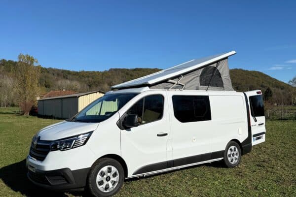 Camionnette bianca con tetto rialzato su prato verde.