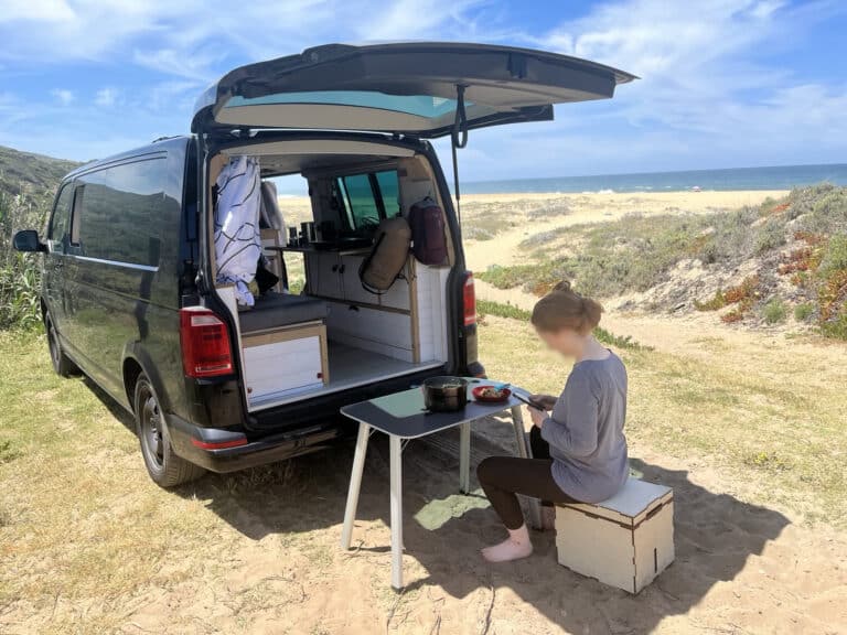 Camping-car aménagé sur plage ensoleillée.