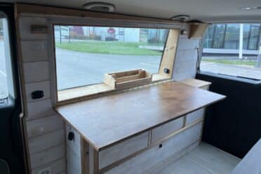 Intérieur aménagé de van avec table en bois.