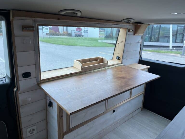 Intérieur aménagé de van avec table en bois.
