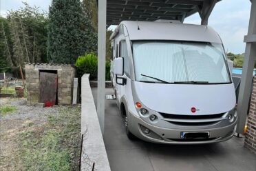 Camping-car stationné sous un abri en plein air.