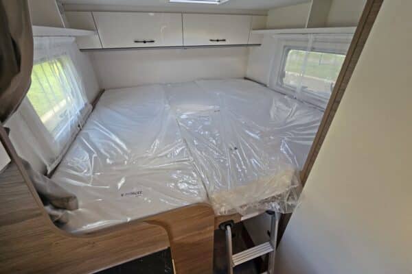 Lit double dans une caravane moderne lumineuse.