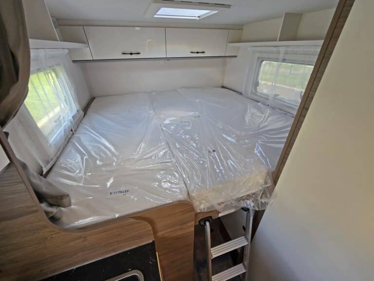 Lit double dans une caravane moderne lumineuse.