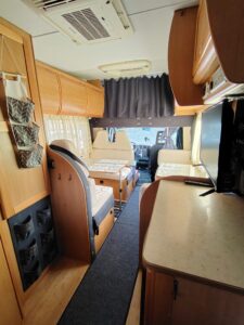 Interno di un camper con sedili e tavolo