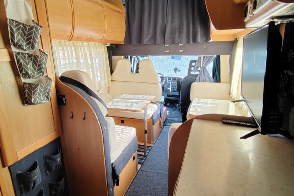 Interno di un camper con sedili e tavolo (Innenräume eines Wohnmobils mit Sedilien und Dachboden)