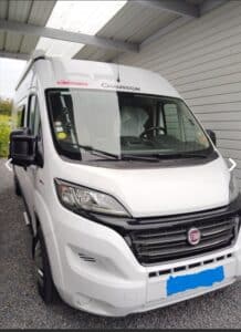 Camping-car blanc garé sous abri.