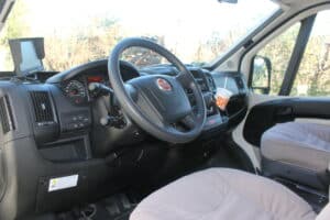 Intérieur d'un véhicule avec volant et tableau de bord.