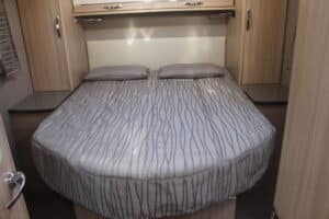 Lit double dans une chambre de camping-car moderne.